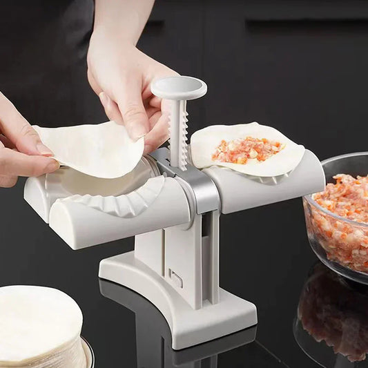 Person using a manual food processor to make noodles on a black surface.