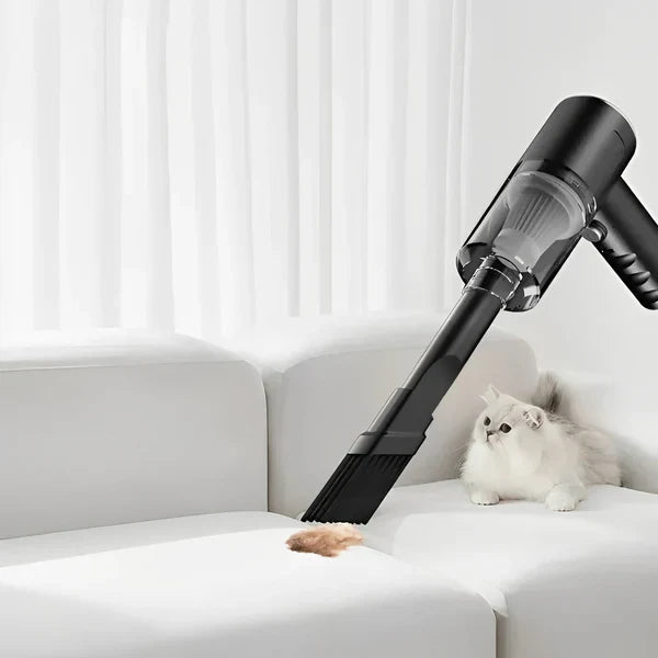 Handheld vacuum cleaner cleaning a white sofa with a cat sitting nearby