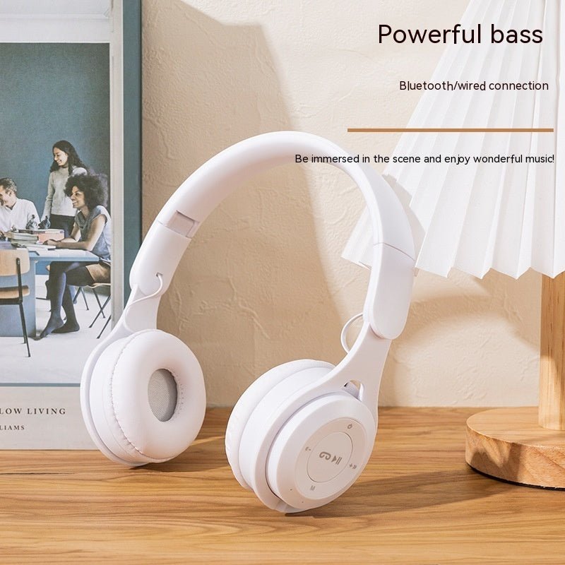 White headphones on a wooden surface with text about powerful bass and connection options.